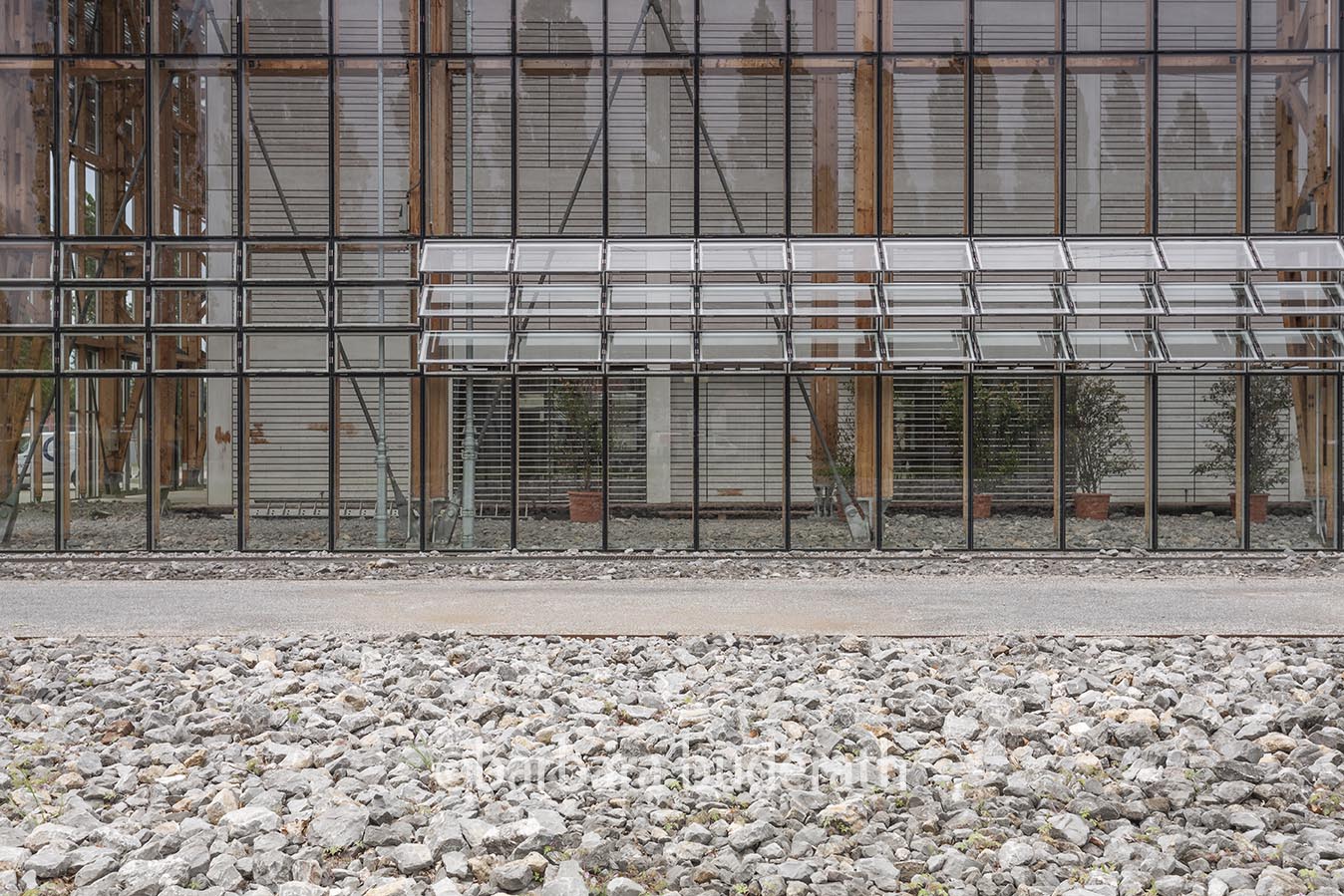 Detailaufnahme der verglasten Gebäudefläche mit Blick auf die innenliegenden Gebäude der Weiterbildungsakademie Mont-Cenis in Herne