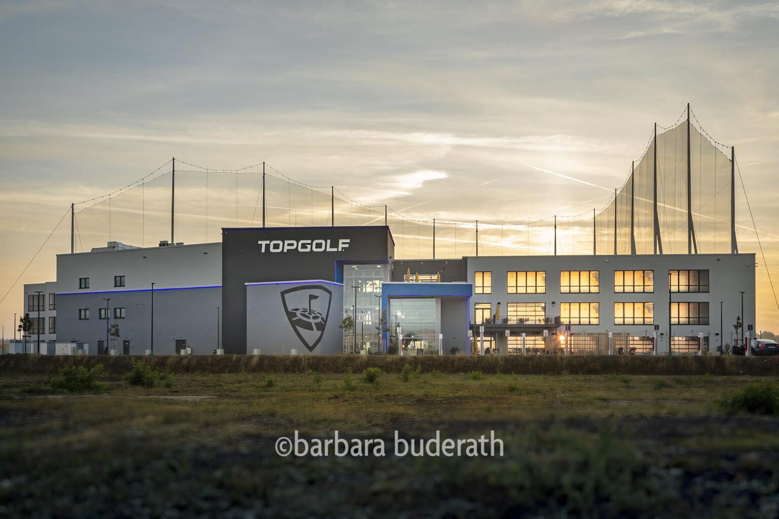 Architekturfoto: Vorderansicht der Sportanlage Topgolf in Oberhausen im Sonnenaufgang