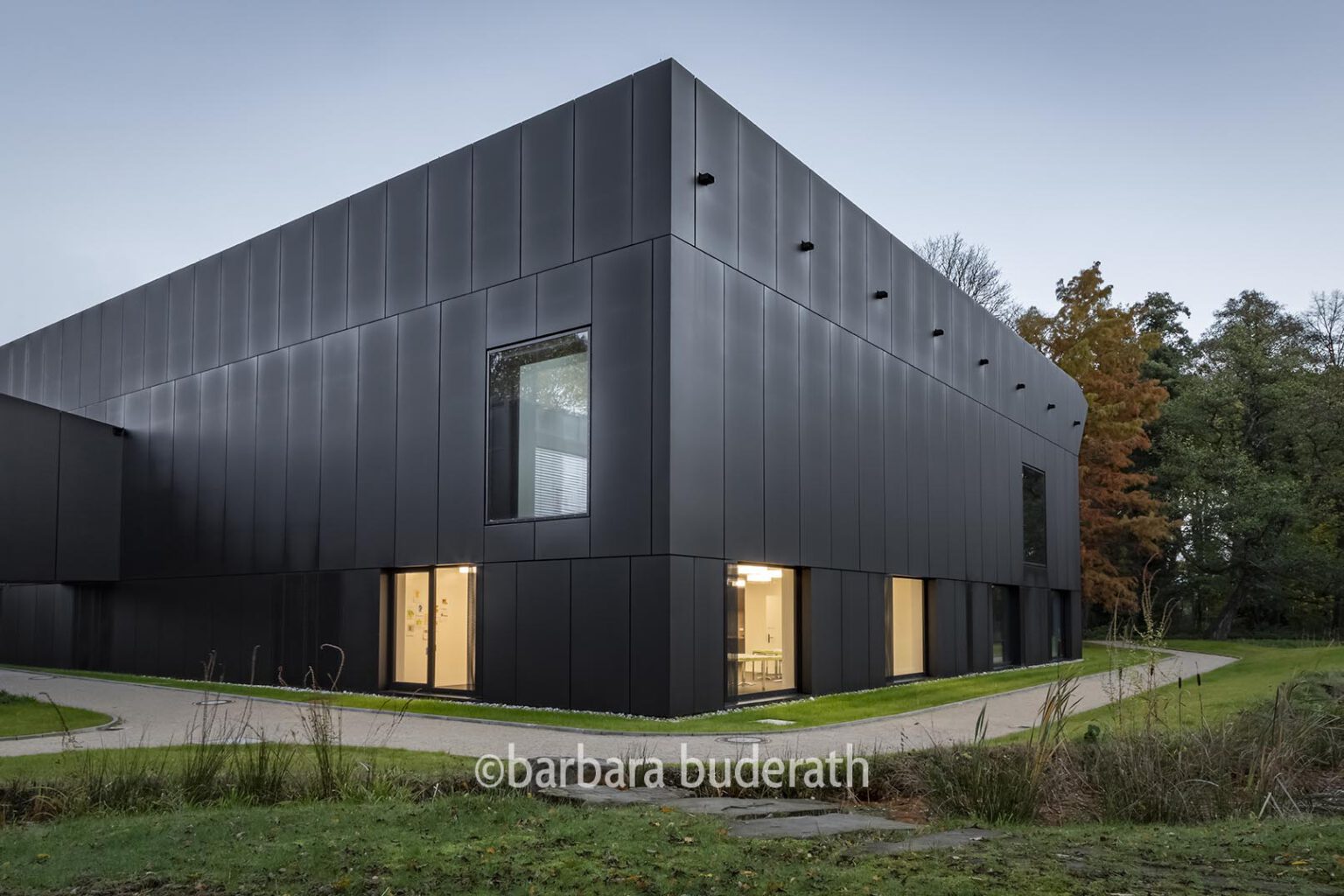 Architekturfoto der neuen Josef-Albers-Galerie im Stadtgarten in Bottrop am frühen morgen mit erleuchteten Fenstern