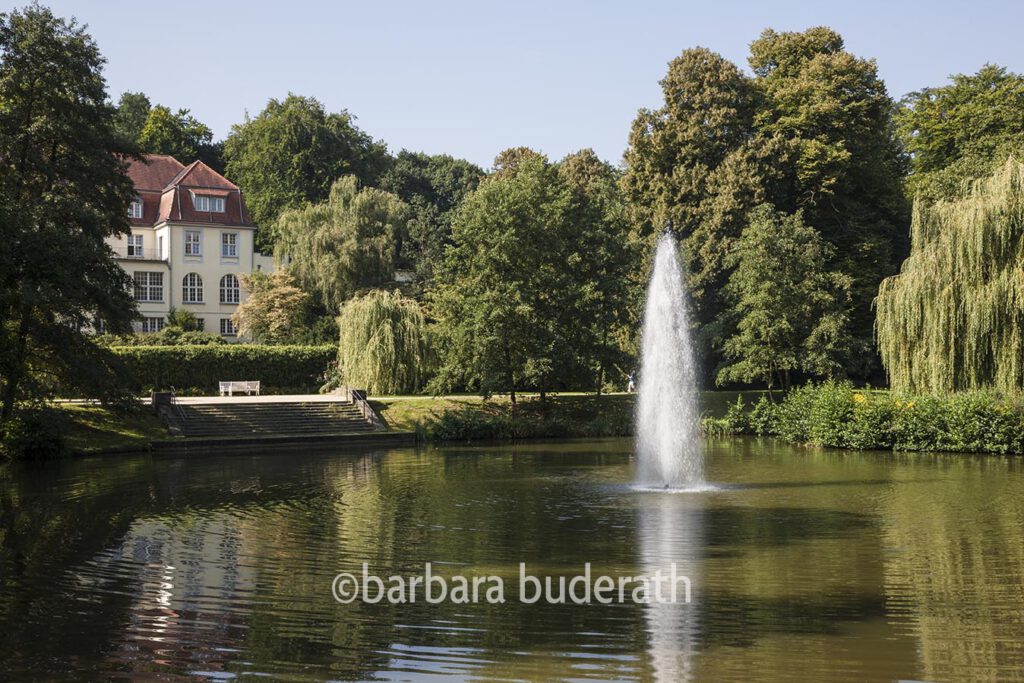 Theater an der Ruhr im ehemaligen Solebad Raffelberg in Mülheim an der Ruhr mit Teich des Kurparks im Vordergrund